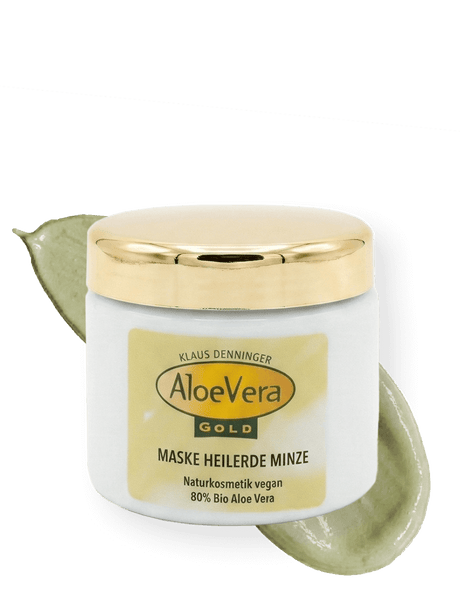 Tiegel der Aloe Vera Gold Creme Maske Heilerde Minze zur Gesichtsreinigung mit einem Cremestrich im Hintergrund
