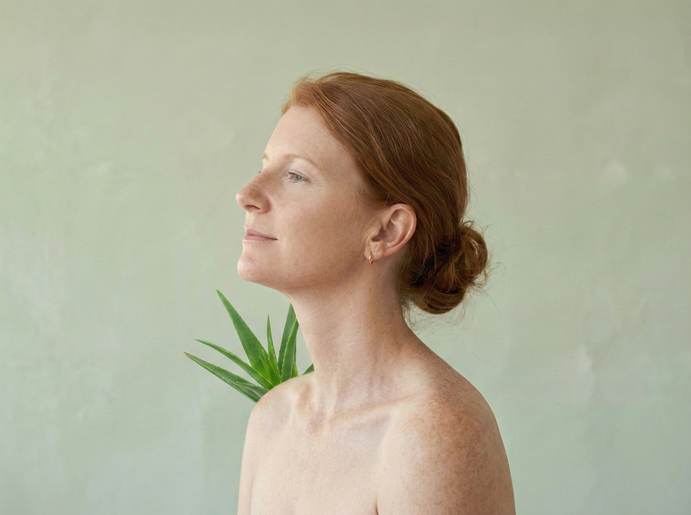 Frau mit strahlender Haut präsentiert reine Bio Aloe Vera Pflege für das Gesicht