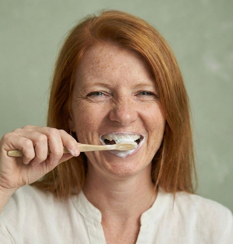 Lächelndes Model putzt sich die Zähne mit Aloe Vera Gold Bio Zahncreme